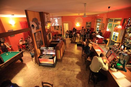 un gruppo di persone seduti in una stanza con tavolo da biliardo di Sunflower Beach Backpacker Hostel a Rimini