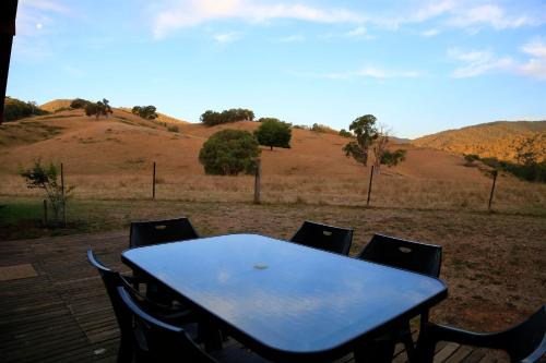 a blue table and chairs with a view of a field at Jamieson Valley Retreat in Howqua
