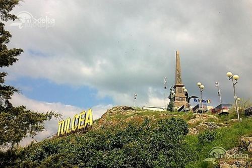 a sign on top of a hill with a monument at Pensiunea Melisa in Tulcea