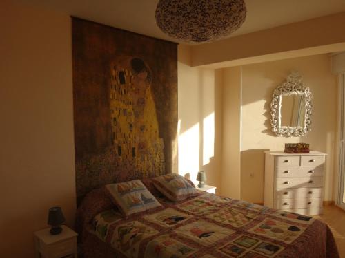 1 dormitorio con cama, tocador y espejo en Torremar I en Torredembarra
