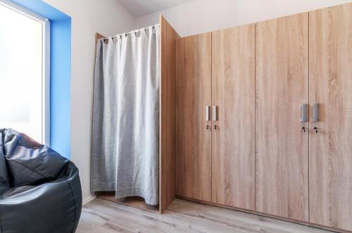 a room with wooden cabinets and a shower curtain at Sky Hostel in Zadar