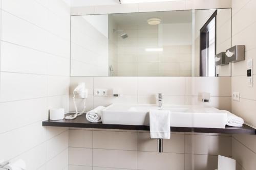a white bathroom with a sink and a mirror at Appartements Solaris in Sölden