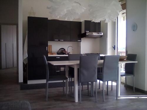 アローナにあるcasa luminosaのキッチン(黒いキャビネット、テーブル、椅子付)