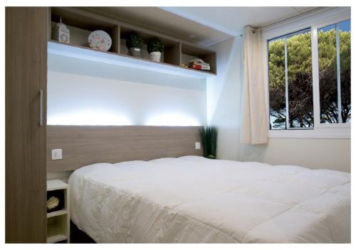 ブドーニにあるCamping Village Pedra e Cupaのベッドルーム(白いベッド1台、窓付)
