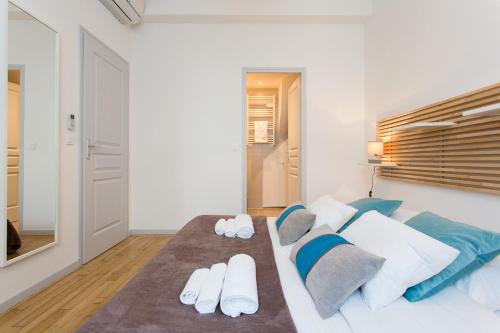 - une chambre avec un lit doté d'oreillers blancs et bleus dans l'établissement Teisseire Accomodations, à Cannes