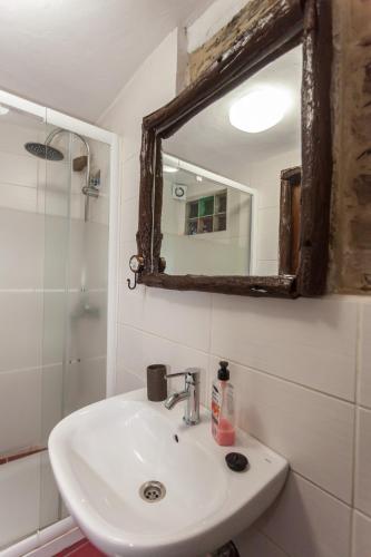 a bathroom with a sink and a mirror at Talasnal Montanhas de Amor in Lousã