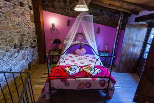 a bedroom with a bed with a canopy at Talasnal Montanhas de Amor in Lousã