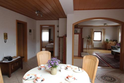 a room with a table and chairs and a living room at Gästehaus Heimenberg in Bad Rippoldsau-Schapbach