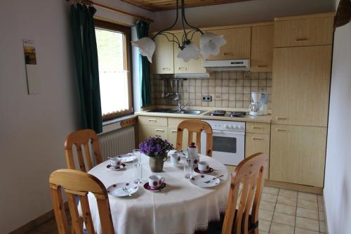 a kitchen with a table with a white table cloth at Gästehaus Heimenberg in Bad Rippoldsau-Schapbach