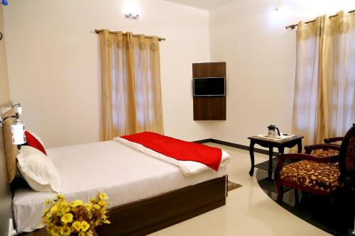 a bedroom with a bed and a chair and a television at Premier Inn in Yercaud