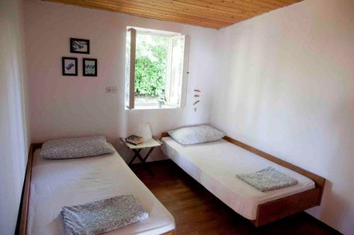 Duas camas num quarto com uma janela em Holiday Home Dajla 35 em Novigrad Istria
