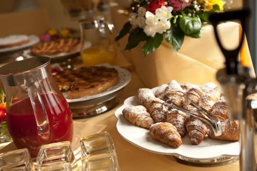een tafel met borden met gebak en taarten bij Hotel Giardino Inglese in Palermo