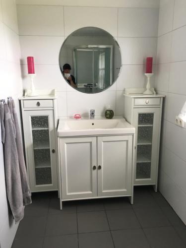 a bathroom with a white sink and a mirror at Str&yacute;ta Guesthouse in Hverager&eth;i