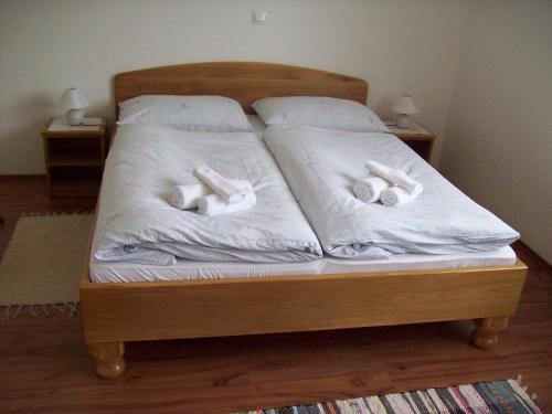 a bed with white sheets and three towels on it at House Mara in Korenica