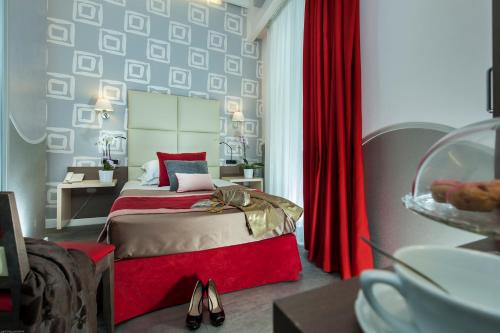 a bedroom with a bed with red sheets and a red curtain at Demetra Hotel in Rome