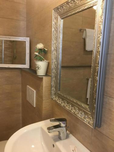 a bathroom with a gold mirror and a sink at Nonna's Affittacamere in Sanremo