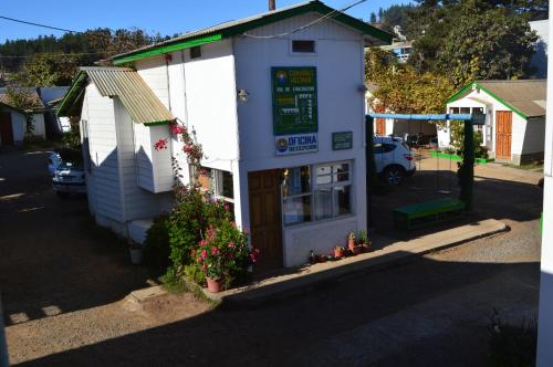 a small white building with a sign on it at Cabañas Hecmar in Pichilemu