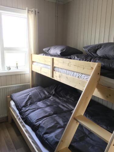 two bunk beds in a room with a window at Strýta Guesthouse in Hveragerði