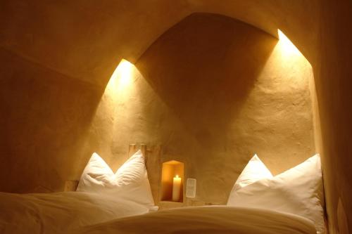 sypialnia z 2 łóżkami z białymi poduszkami i świecą w obiekcie Turm zu Schloss Schedling w mieście Trostberg an der Alz