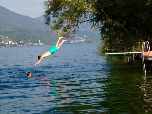 a person jumping into the water in a lake at Waldstrand Berger in Seeboden