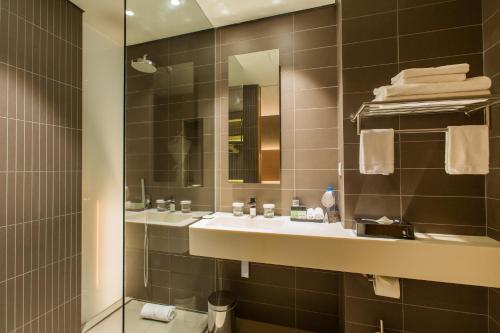 a bathroom with a sink and a mirror at Noom Hotel Conakry in Conakry