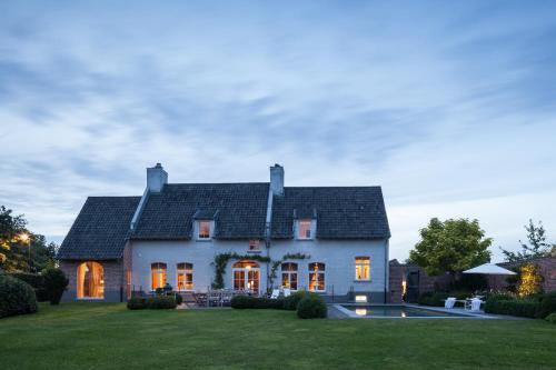 ein großes weißes Haus mit einem großen Hof in der Unterkunft B&B De Lievde in Lievegem