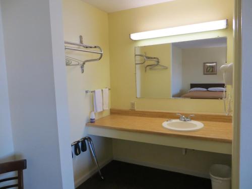 La salle de bains est pourvue d'un lavabo et d'un miroir. dans l'établissement State Motel Haines City, à Haines City