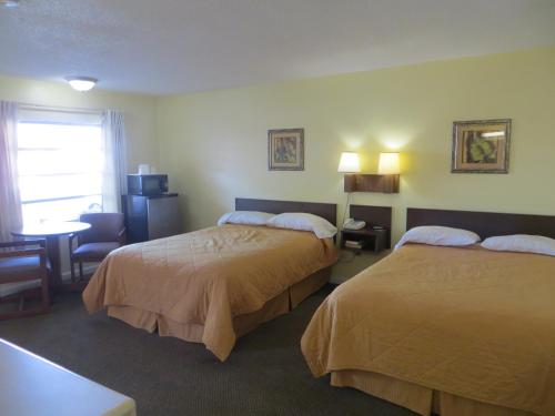 Cette chambre comprend deux lits et un bureau. dans l'établissement State Motel Haines City, à Haines City