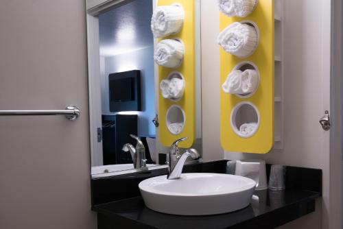 a bathroom with a sink and a mirror with towels at Motel 6-Pottstown, PA in Pottstown