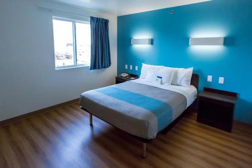 a blue room with a bed and a window at Motel 6-Pottstown, PA in Pottstown