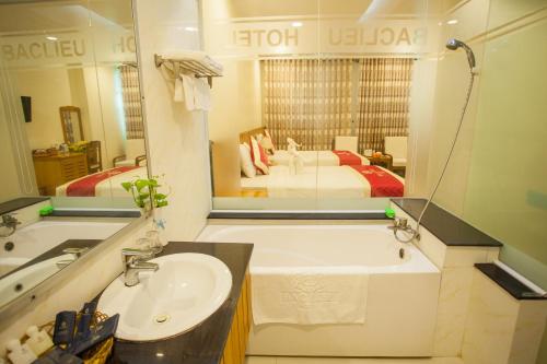 La salle de bains est pourvue d'un lavabo et d'un grand miroir. dans l'établissement SÀI GÒN - BẠC LIÊU Hotel, à Bạc Liêu