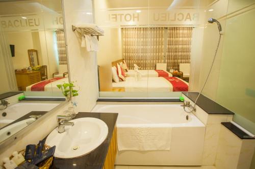 a bathroom with a sink and a large mirror at SÀI GÒN - BẠC LIÊU Hotel in Bạc Liêu