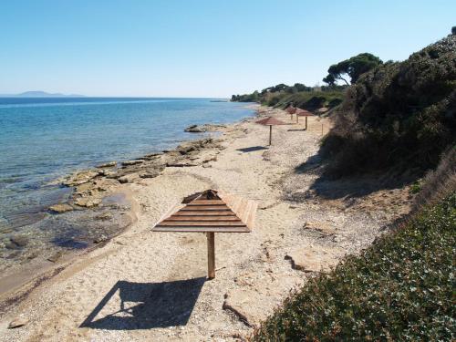 a group of umbrellas sitting on a beach at Villa Verde Apart-Hotel in Nea Makri