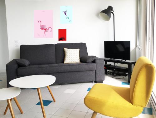 salon z kanapą, stołem i krzesłami w obiekcie Superbe appartement sur la plage - Le Zénith w mieście Palavas-les-Flots