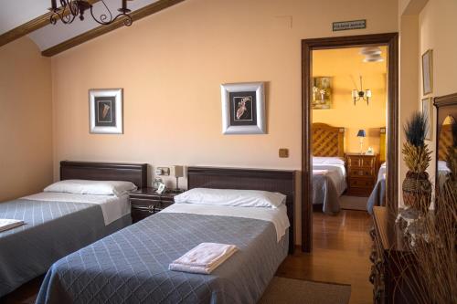 a hotel room with two beds and a mirror at La Posada de Clotilde in Cella