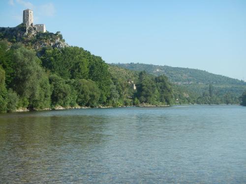 a view of a river with a castle in the distance at Riverside Guesthouse in Počitelj
