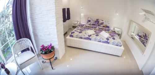 a small bedroom with a bed and a balcony at Aloha Apartments with pool in Skopje