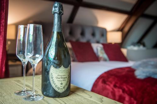 a bottle of wine and two glasses on a table at St Nicholas Boutique Hotel in Shrewsbury
