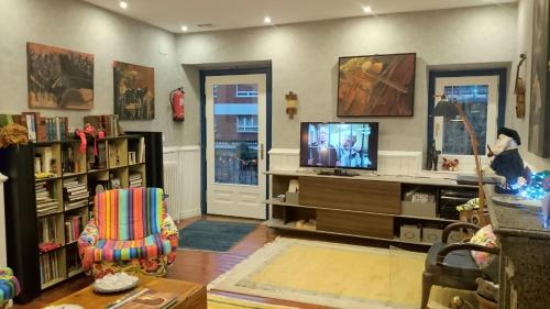 a living room with a tv and a chair at Hotel Ormazabal in Bergara