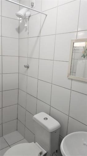 a white bathroom with a toilet and a sink at Hotel Bella Júlia in Joinville