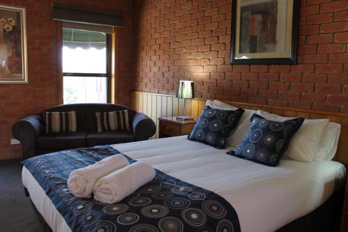 a bedroom with a large bed with towels on it at Bakery Hill Motel in Ballarat