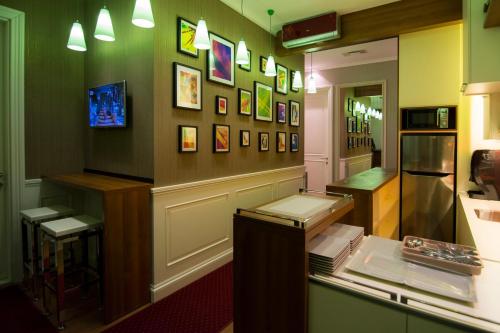 ベオグラードにあるB&B Wimbledon Garni Conceptのカウンター付きのお部屋、壁に飾られた絵画