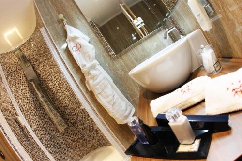 a bathroom with a sink and a toilet and a shower at Cavallino Lovely Hotel in Andalo