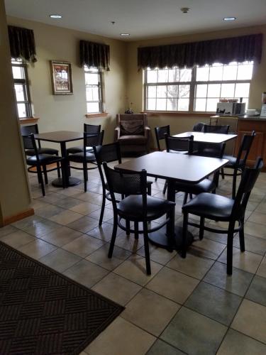 a dining room with tables and chairs and windows at Americas Best Value Inn Bryant in Bryant