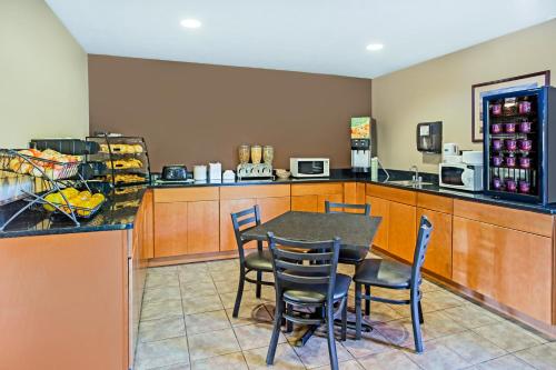 a kitchen with a table and chairs and a refrigerator at Microtel Inn & Suites by Wyndham Holland in Holland