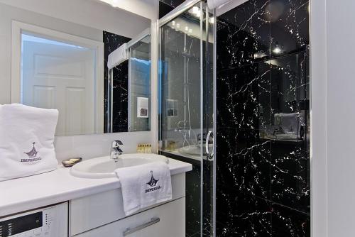 łazienka z umywalką i przeszkloną kabiną prysznicową w obiekcie Imperial Apartments - Balticana w mieście Sopot