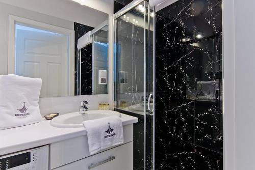 ソポトにあるImperial Apartments - Balticanaのバスルーム(洗面台、ガラス張りのシャワー付)