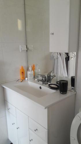 a white bathroom with a sink and a mirror at Casa Zona Velha - Caetano in Funchal