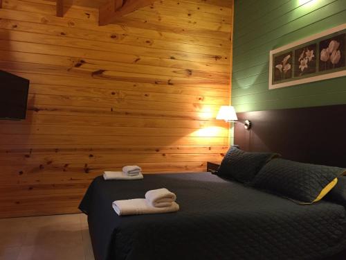 a bedroom with a bed with two towels on it at Encanto del Rio in Villa La Angostura