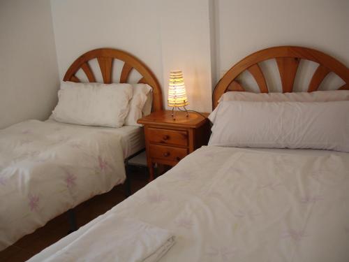 a bedroom with two beds and a lamp on a night stand at Terraced House - Zand Properties in Benidorm